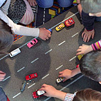 Ausschnitt aus dem Videospot 'Rettungsgasse ist kinderleicht': Kinder spielen auf einem Verkehrsteppich Ausschnitt aus dem Videospot 'Rettungsgasse ist kinderleicht': Kinder spielen auf einem Verkehrsteppich