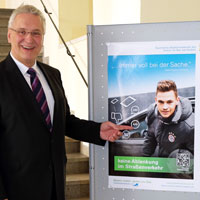Verkehrsminister Joachim Herrmann zeigt auf das Plakat zur Aktion "Keine Ablenkung im Straßenverkehr" mit Joshua Kimmich Verkehrsminister Joachim Herrmann zeigt auf das Plakat zur Aktion "Keine Ablenkung im Straßenverkehr" mit Joshua Kimmich